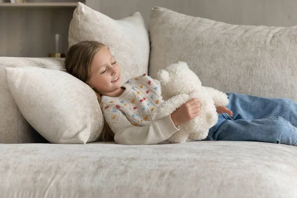 집에서 편안 한 소파에 앉아 쉬고 있는 행복 한 졸린 아이 — 스톡 사진