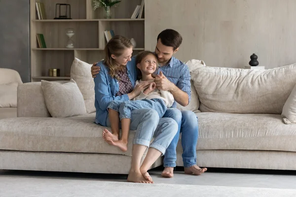 Gelukkig duizendjarige ouders houden vrolijke dochter kind in de armen — Stockfoto