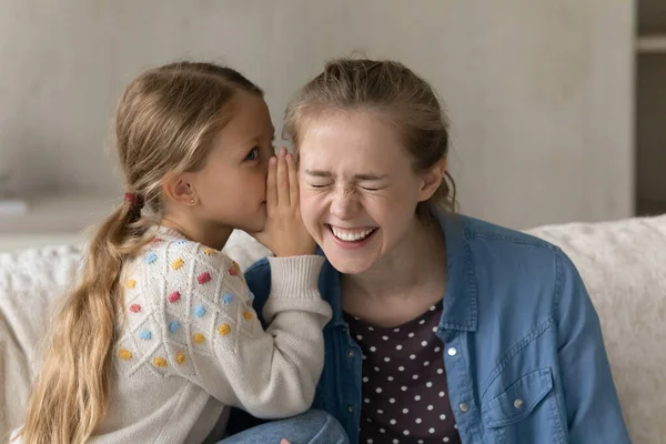 Schattig kind vertellen geheim naar gelukkig lachende oudere zus, nanny — Stockfoto