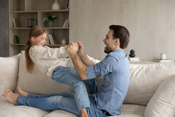 Cheerful dad and kid playing active games on comfortable couch — Stock Photo, Image