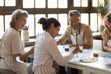 Farklı yaşlarda mutlu insanlar resim çiziyor..