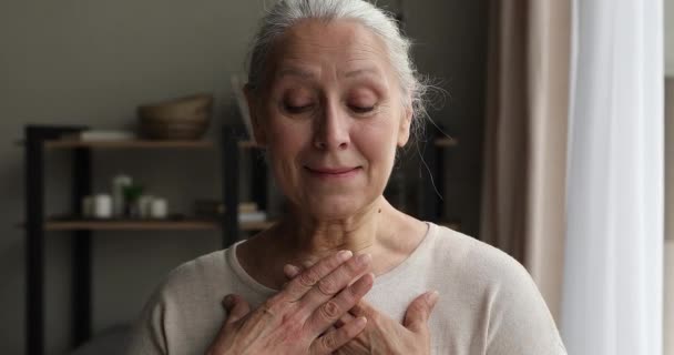 Äldre kvinna sätta handflator på bröstet visar tacksamhet känns hoppfull — Stockvideo
