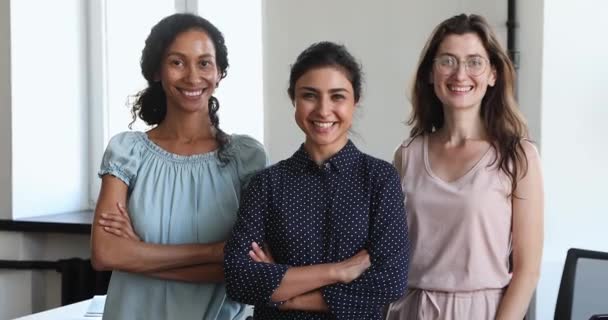 Três empresárias multiétnicas posam no local de trabalho sorriem olham para a câmera — Vídeo de Stock