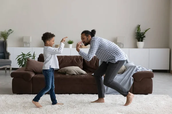 Feliz niño afroamericano pequeño bailando con padre cariñoso. —  Fotos de Stock