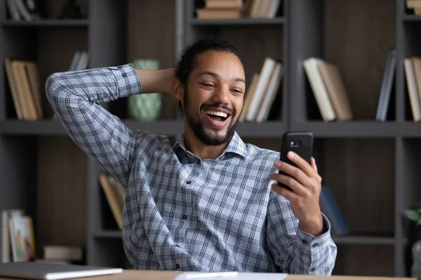 Feliz espantado jovem afro-americano homem olhando para a tela do celular. — Fotografia de Stock