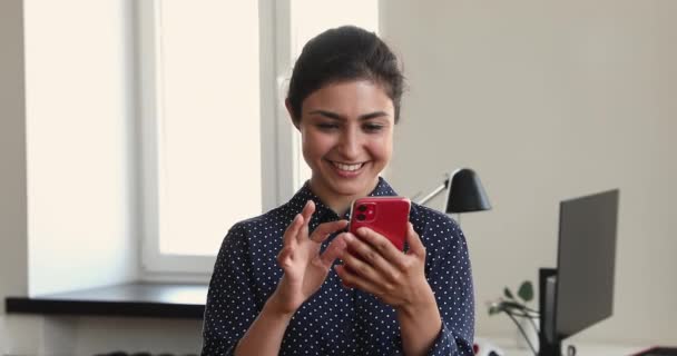 Сотрудница офиса индийской женщины с помощью смартфона, стоящего в офисе — стоковое видео