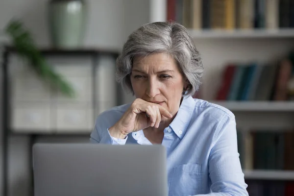 Umsichtige ältere Geschäftsfrau, die am Computer arbeitet. — Stockfoto