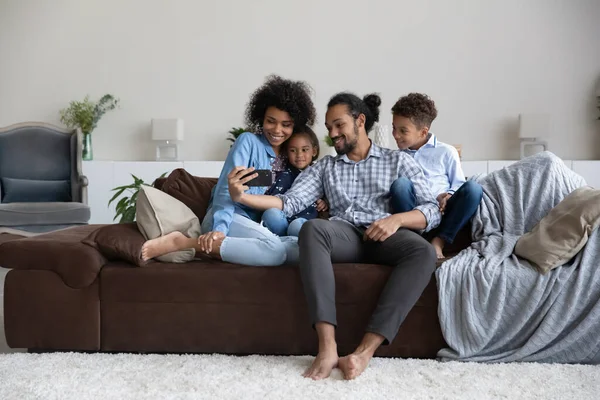 Šťastný milující mladá afroamerická rodina pomocí mobilního telefonu. — Stock fotografie