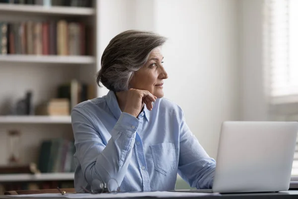 Pensive středního věku žena rozptýlena od počítačové práce. — Stock fotografie