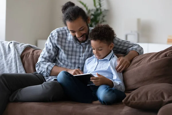 Happy bonding Afrikaanse Amerikaanse familie met behulp van digitale computer tablet. — Stockfoto