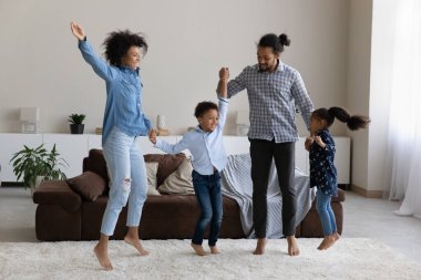 Modern oturma odasına atlayan mutlu Afrikalı Amerikalı aile..