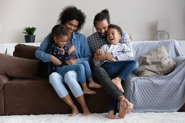 幼いアフリカ系アメリカ人の両親が小さな子供をくすぐる. — ストック写真