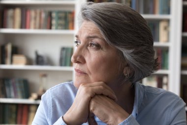 Uzaktan bakan düşünceli orta yaşlı bir kadın..