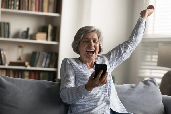 Nadšení stará žena slaví online loterie vyhrát. — Stock fotografie