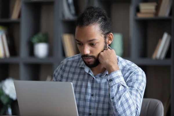 Jovem empresário afro-americano concentrado trabalhando em informática. — Fotografia de Stock