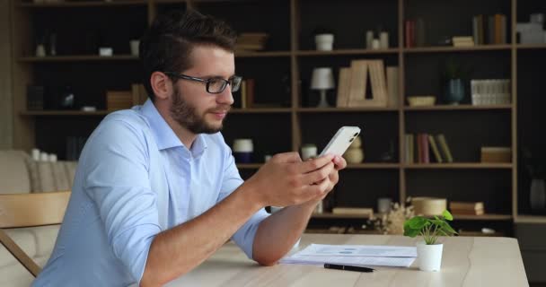 점잖은 사업가가 스마트폰을 사용하여 집에서 고객 과 메시지를 보내는 모습 — 비디오