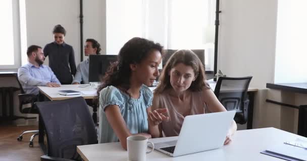 Kvinnliga kollegor pratar om att titta på bärbar dator, diskutera uppgifter på arbetsplatsen — Stockvideo