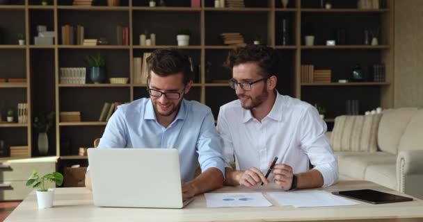 Νέοι άνδρες ελεύθεροι επαγγελματίες εργάζονται σε φορητό υπολογιστή μαζί με δίδυμο αδελφό — Αρχείο Βίντεο