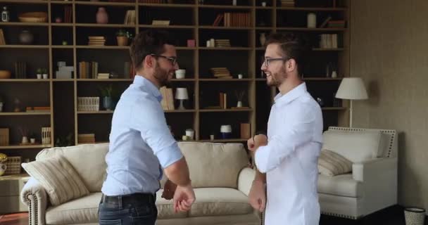 Fröhliche junge erwachsene Zwillingsbrüder führen lustiges Grußritual auf — Stockvideo