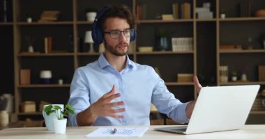 Kulaklık takan iş adamı laptop 'dan önce webcam konferansında fikir sundu