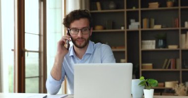 Laptop ekranından önce müşteriye telefonla danışmakla meşgul milenyum yöneticisi