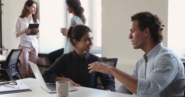 Hispanic och indiska arbetskamrater talar sitta vid bordet på kontoret — Stockvideo