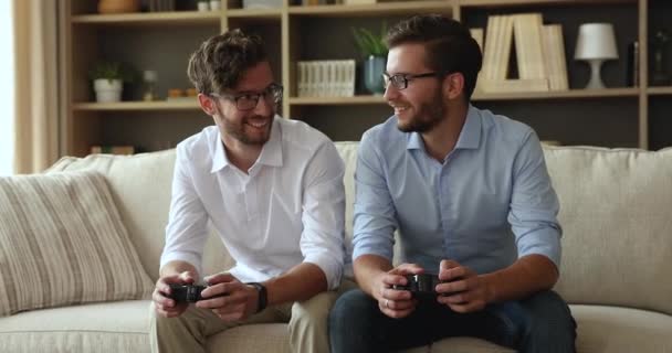 Zwei junge Männer Zwillingsbrüder genießen das gemeinsame Spielen von Konsolen-Videospiel — Stockvideo