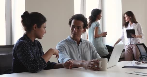 Compañeros de trabajo indios e hispanos sentados a la mesa hablando, discutiendo negocios — Vídeo de stock