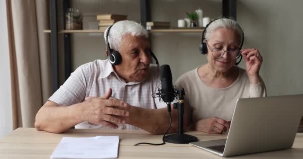 Äldre makar bär headset titta på laptop prata i mikrofon — Stockvideo