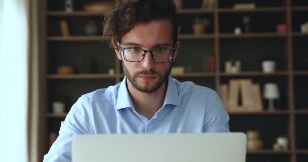Concentrato millenario maschio sedersi dallo schermo del computer portatile impegnato nel lavoro — Video Stock