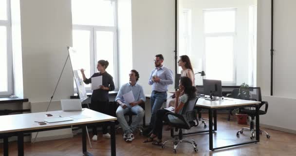 Femme d'affaires indienne écrit sur un tableau à feuilles mobiles pendant des brainstorms avec des collègues multiethniques — Video