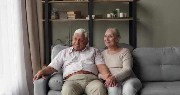 Dromerige oudere echtgenoten zitten op de bank te dagdromen op zoek naar afstand — Stockvideo