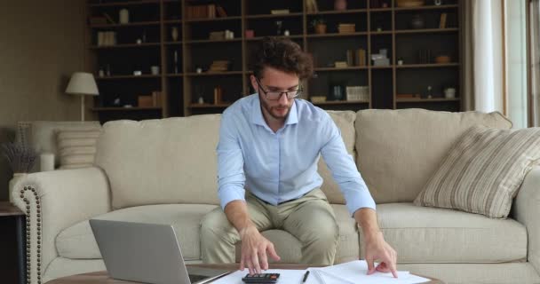 Verward jongeman doen boekhoudkundige papierwerk omgaan met financiële problemen — Stockvideo