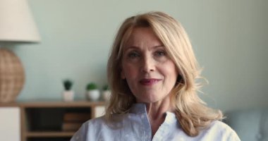 Daha yaşlı, sarışın, çekici bir kadının portresi. Kameraya bak.