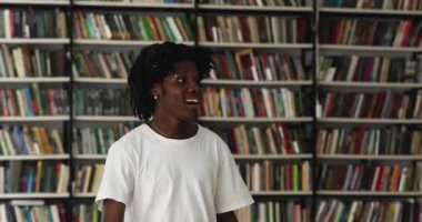 Genç zenci öğrenci Asyalı bir grup arkadaşıyla kütüphanede buluşuyor.