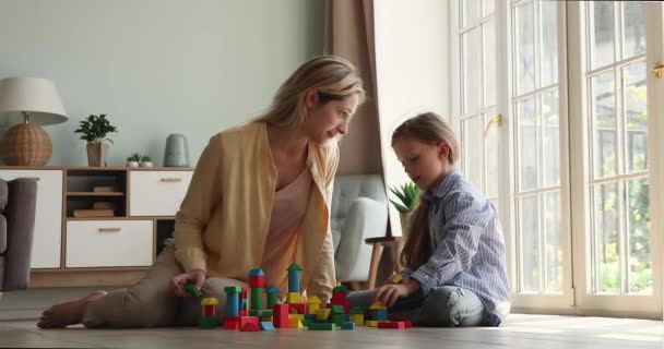 Moeder en dochter spelen samen houten kubussen thuis — Stockvideo