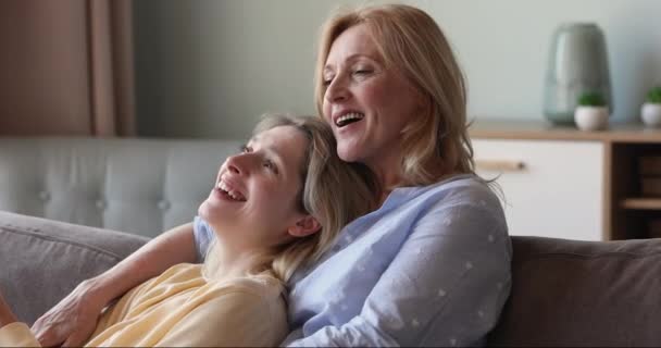 Küçük kızı, büyük annesi kanepede rahat rahat sohbet ediyor. — Stok video