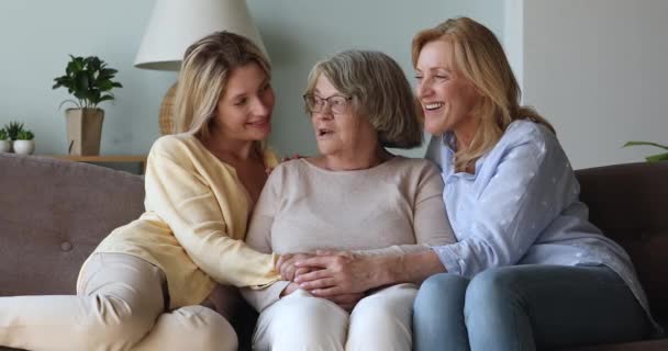 Mujeres de tres generaciones teniendo una agradable conversación sentadas en el sofá — Vídeos de Stock