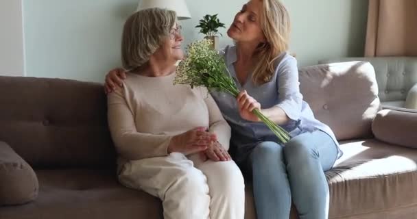 Любящая женщина средних лет поздравляет маму 80-х с днем рождения — стоковое видео