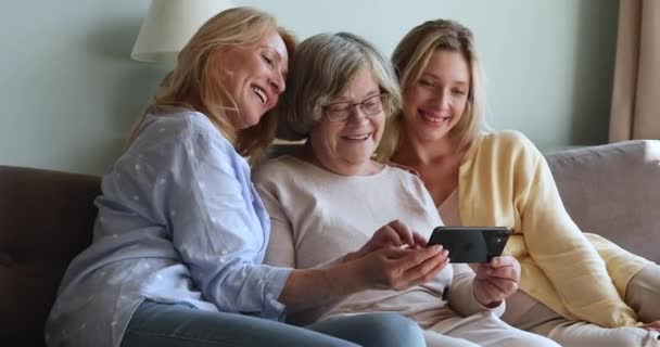 Πολλαπλών γενεών οικογένεια των γυναικών που διασκεδάζουν χρησιμοποιώντας smartphone στο σπίτι — Αρχείο Βίντεο