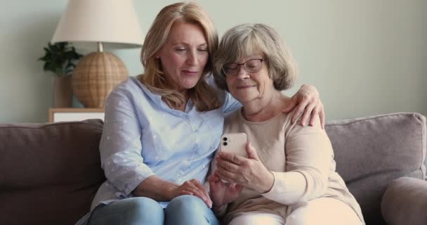 Woman her older mother having fun using app on cellphone — Stock Video