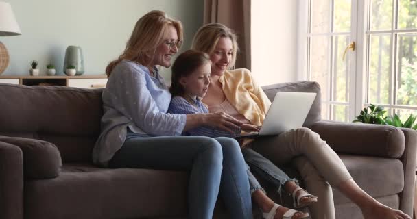 Багатоповерхова сім'я жінок сидить на дивані з ноутбуком — стокове відео