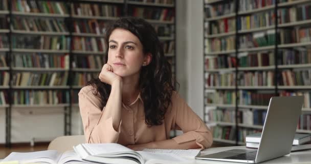 Thoughtful young Latin woman scientist consider on problem at library — Stock Video