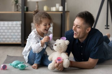 Mutlu genç baba küçük kızıyla oyuncak oynuyor..