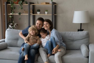 Mutlu, sevgi dolu ebeveynler evde tatlı çocuklarla dinleniyor..