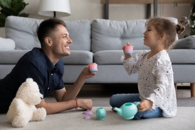 Mutlu genç baba tatlı küçük kızıyla oynuyor..