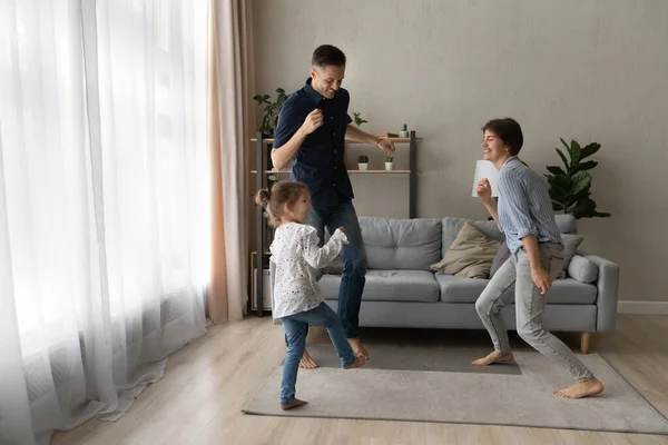 Szczęśliwy aktywny dwa pokolenia rodzina taniec razem w domu. — Zdjęcie stockowe