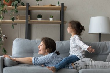 Neşeli annesinin arkasında oturan sevimli çocuk..