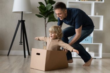 Gülümseyen, şefkatli bir baba küçük bir bebekle oynuyor..