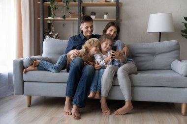 Evde cep telefonu uygulamaları kullanarak rahat bir aile..